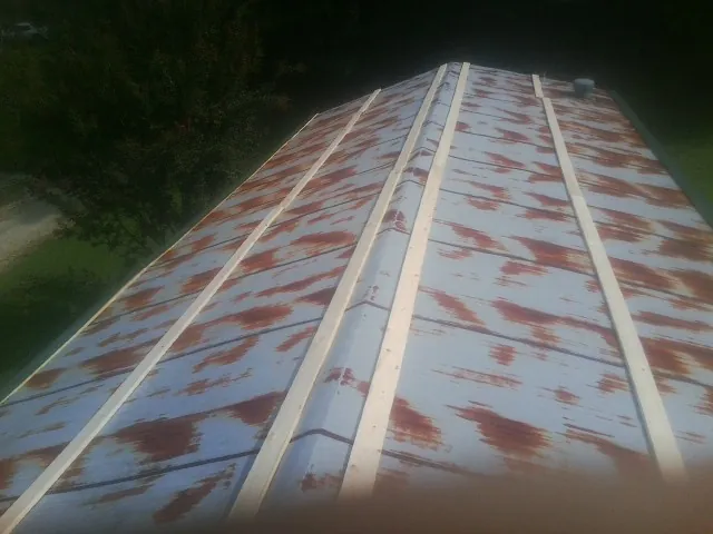 Rusted metal roof panels with new wood purlins before replacement — Storm Damage Roof Repair in Pearblossom by Roofing Brothers
