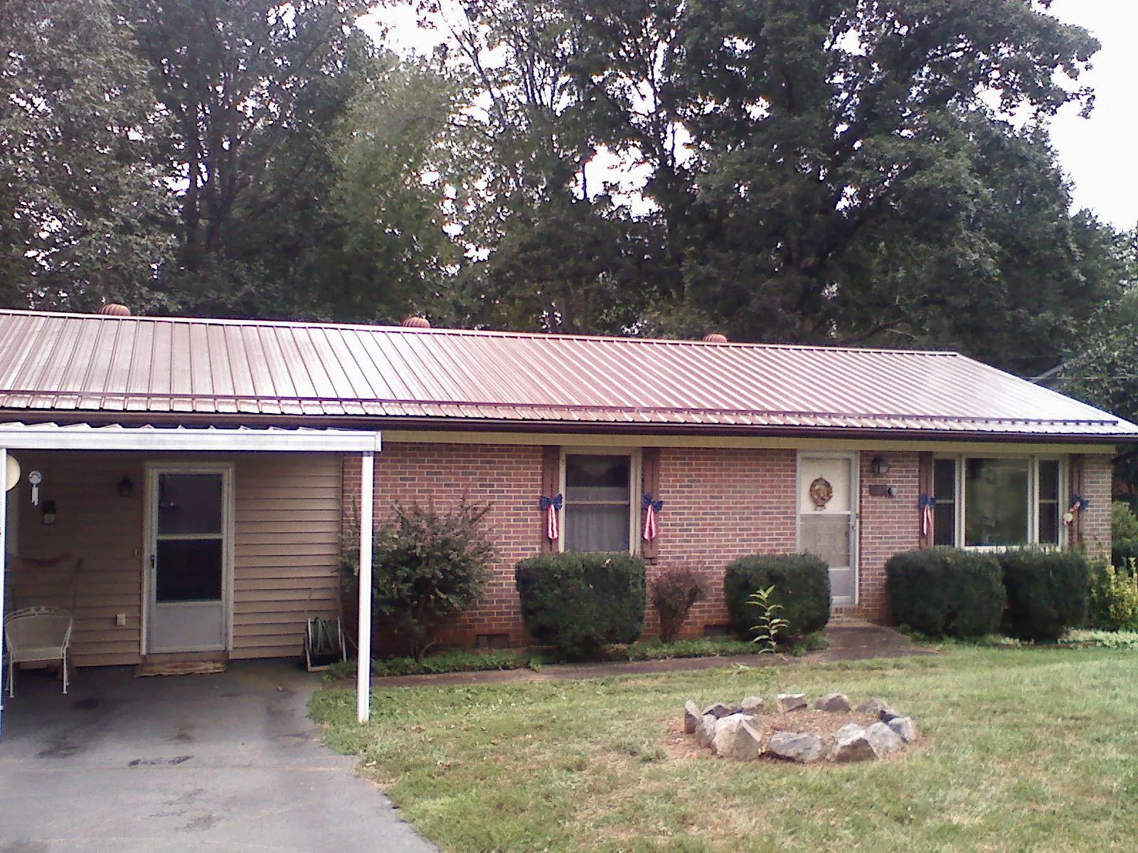 Bronze metal roof and carport on a brick ranch home — Roof Repair work by our crew in Pearblossom